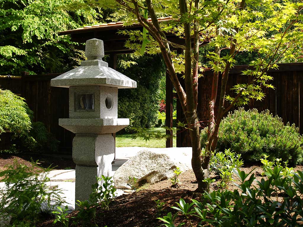  Japanese stone lantern at the side of the wooden gate.